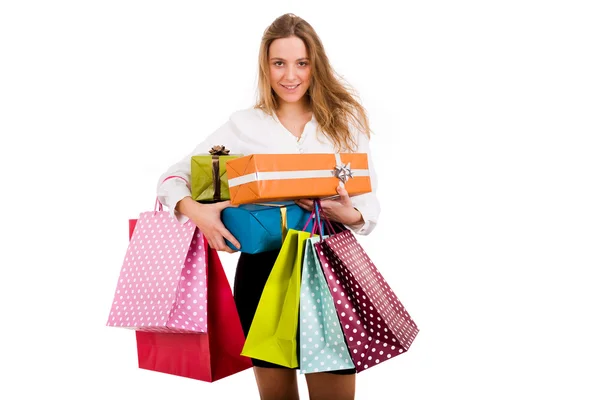 Usměvavá mladá žena nošení nákupní tašky a dary na bílé ba — Stock fotografie