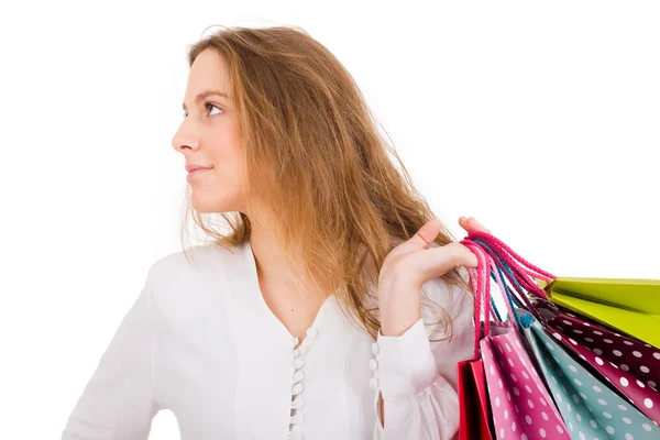 Portrait of young beautiful woman holding shopping bags against — Stock Photo, Image