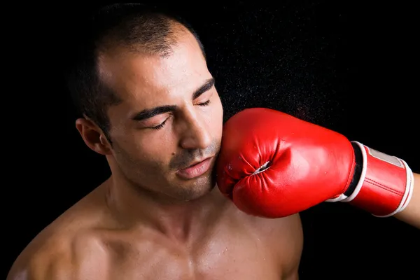 Image of a young boxer getting punched in the face over black ba — Stock Photo, Image
