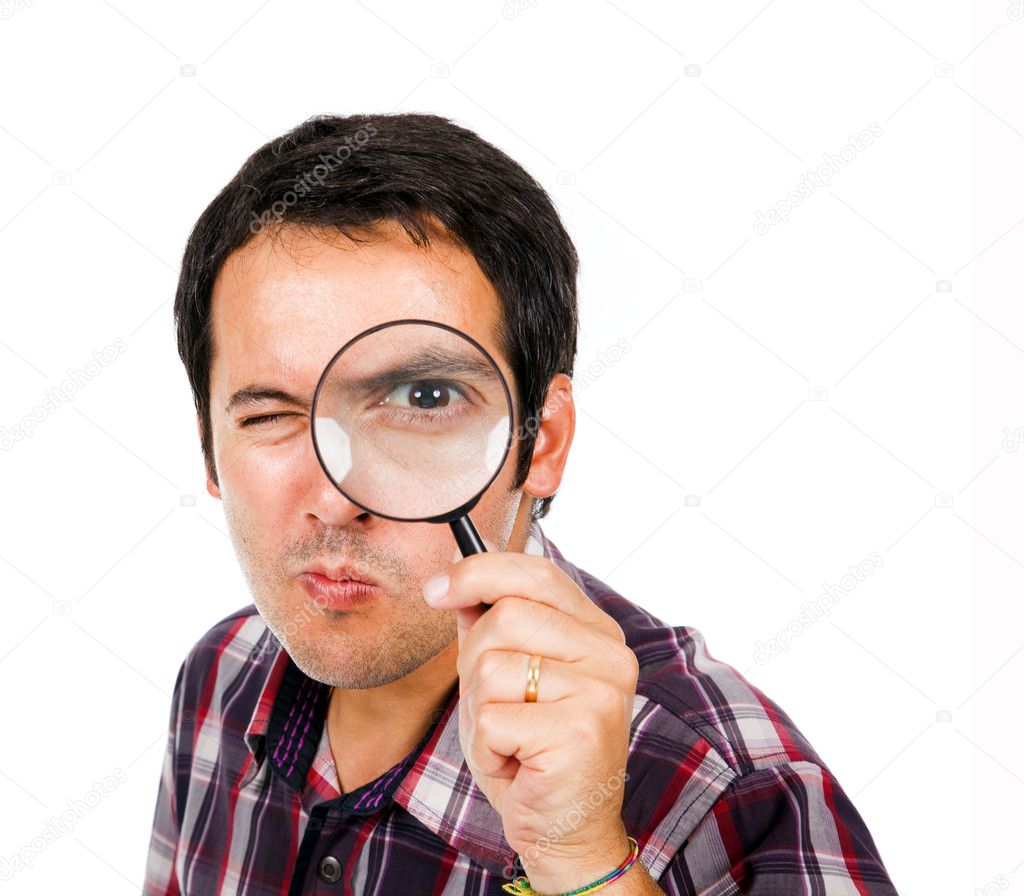 Funny young man looking through magnifying glass, isolated on wh