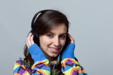 Young beautiful woman listen music with headphones clipart