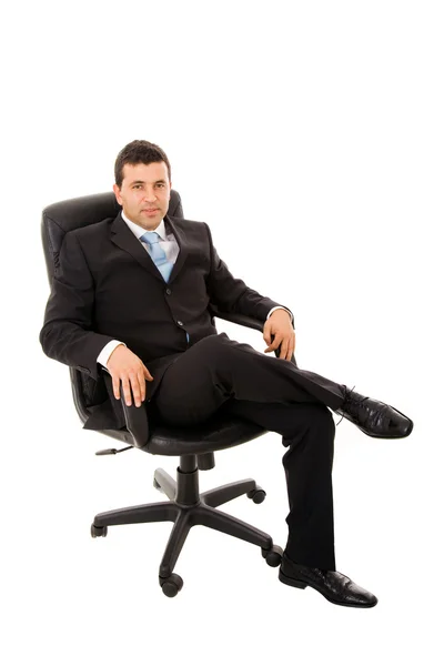 Расслабленный молодой бизнесмен сидит на офисном стуле над белой спинкой — стоковое фото