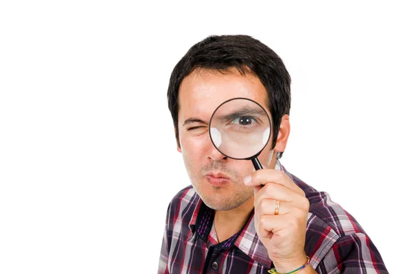 Funny image of a young man looking through magnifying glass, iso — Stock Photo, Image