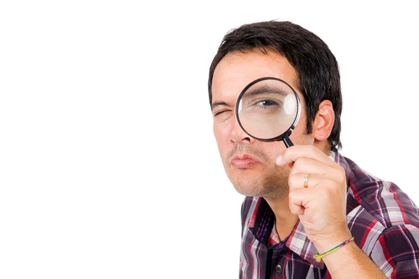 Funny image of a young man looking through magnifying glass, iso — Stock Photo, Image