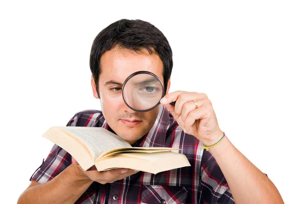 Isol 虫眼鏡で面白い本を読んで若い男 — ストック写真