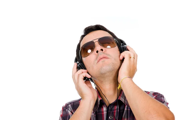 Молодой человек слушает музыку в наушниках против белого бэкгру — стоковое фото