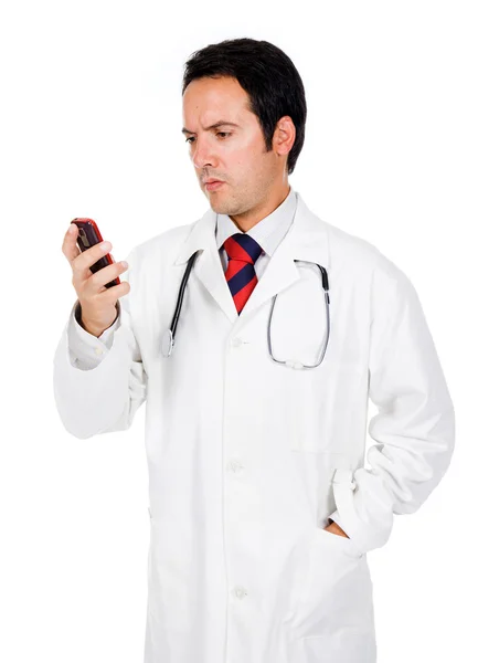 Joven médico leyendo un mensaje por teléfono y buscando preocupado —  Fotos de Stock