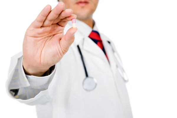 Imagem de um médico masculino segurando uma pílula em fundo branco — Fotografia de Stock