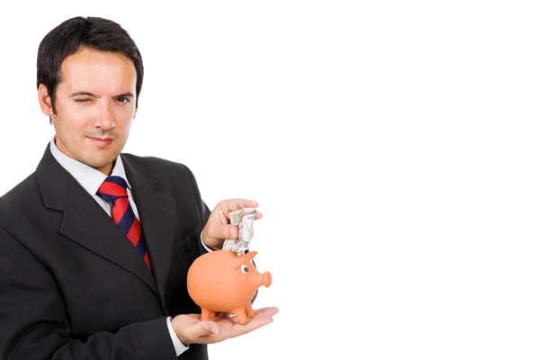 Zakenman geld invoegen in een piggy moneybox, geïsoleerd op — Stockfoto