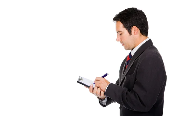 Retrato de pensativo jovem homem de negócios tomando notas contra w — Fotografia de Stock