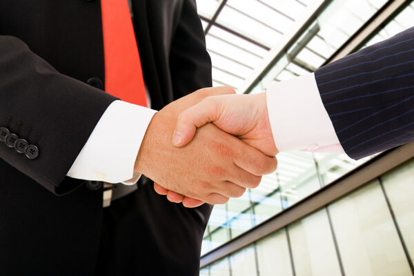 Крупный план, где предприниматели пожимают друг другу руки, договариваются
