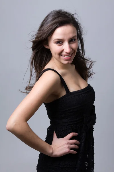 Krásná mladá žena s úsměvem, šedé pozadí — Stock fotografie