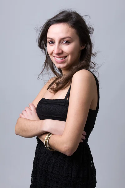 Güzel bir genç kadın gülümseyerek, gri bir arka planı — Stok fotoğraf