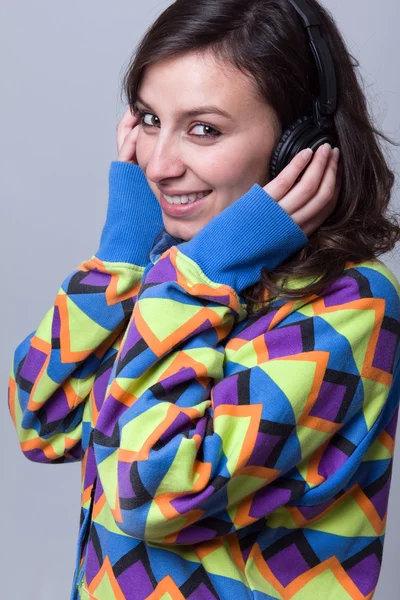 Jeune femme écouter de la musique avec des écouteurs sur un fond bleu — Photo