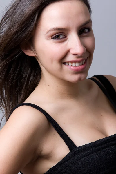Closeup portret van een mooie jonge vrouw die lacht, tegen een g — Stockfoto