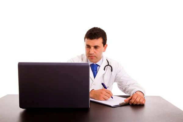 Jovem médico feliz trabalhando em um laptop contra fundo branco — Fotografia de Stock