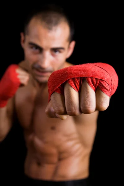 Jovem lutador Boxer sobre fundo preto. Foco na mão — Fotografia de Stock