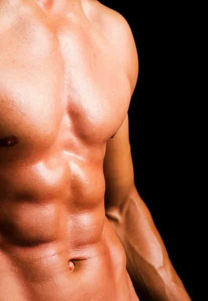 Uomo con torso nudo muscoloso contro sfondo nero — Foto Stock