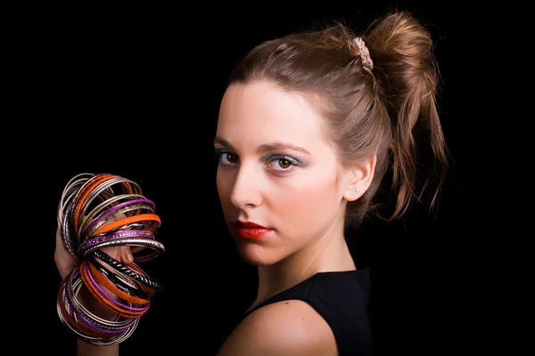 Prachtige jonge vrouw armbanden dragen op zwarte achtergrond — Stockfoto