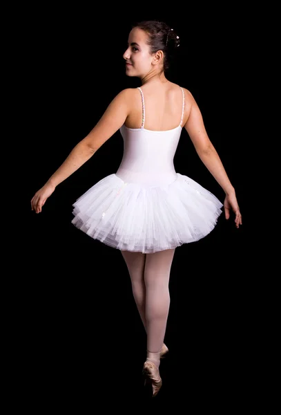Ung flicka balettdansös stående bakifrån på svart bakgrund — Stockfoto