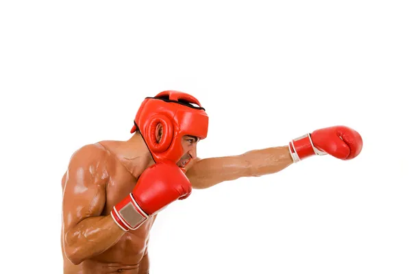 Jovem lutador Boxer com capacete de boxe e luvas fazendo um soco — Fotografia de Stock
