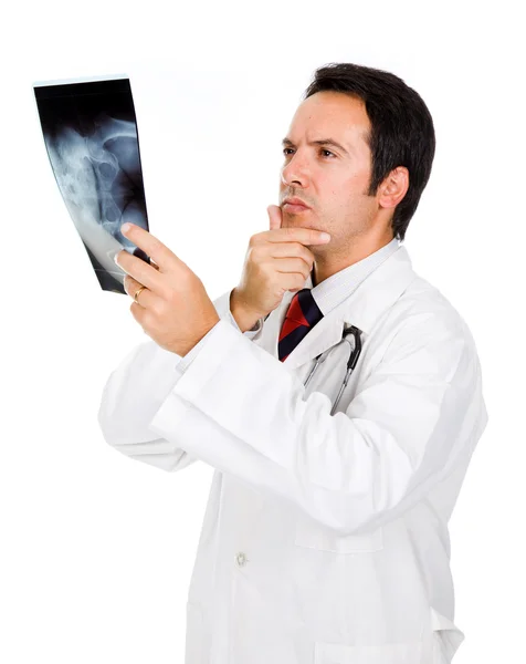 Jovem médico examinando um raio-x sobre fundo branco — Fotografia de Stock