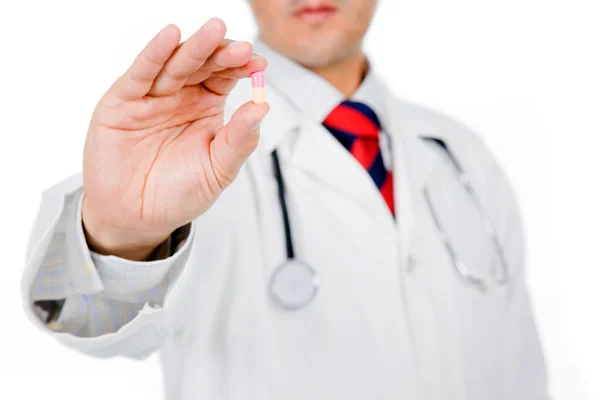 Image of a male doctor holding a pill on white background — Stock Photo, Image