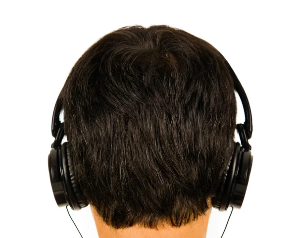 Bakifrån av en man lyssnar musik med hörlurar. (fokus på h — Stockfoto