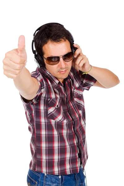 Happy young man with thumb up and listening music — Stock Photo, Image