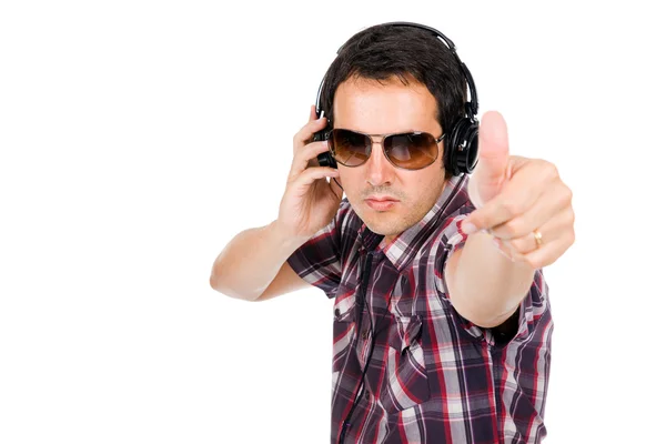 Glücklicher junger Mann mit erhobenem Daumen und Musik hören — Stockfoto