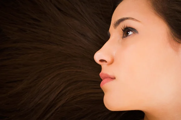 Szép fiatal női arc, hosszú szépség haj mint háttér — Stock Fotó