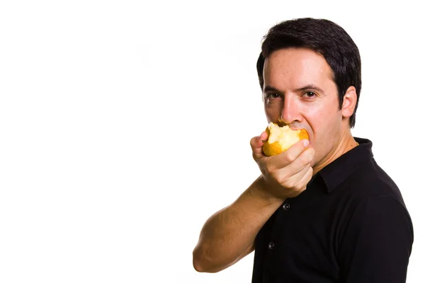 Joven mordiendo una manzana sobre fondo blanco — Foto de Stock