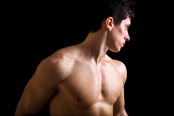 Atrakcyjna mięśni młody człowiek na czarnym tle — Zdjęcie stockowe