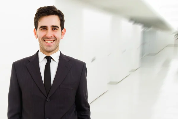 Closeup of a young smiling business man standing at a modern off — Stock Photo, Image