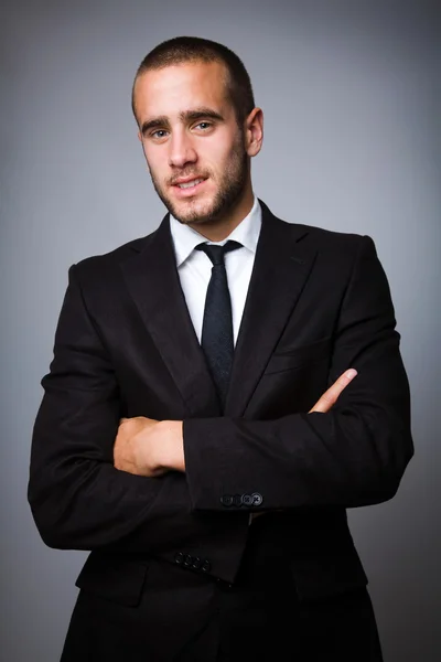 Porträt eines hübschen jungen Geschäftsmannes auf grauem Hintergrund — Stockfoto