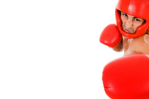 Jovem lutador Boxer com capacete de boxe e luvas fazendo um soco — Fotografia de Stock