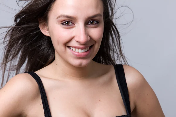 Closeup portrait of a beautiful young woman smiling, against a g — Stock Photo, Image