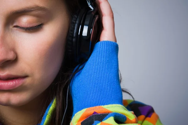 Крупный план молодой девушки, слушающей музыку в наушниках — стоковое фото