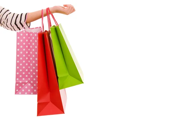 Mano femenina sosteniendo coloridas bolsas de compras, aisladas sobre blanco —  Fotos de Stock