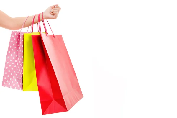 Vrouwelijke hand met kleurrijke boodschappentassen, geïsoleerd op wit — Stockfoto