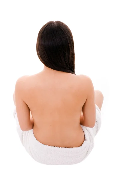 Belle jeune femme nue avec serviette assise du dos — Photo
