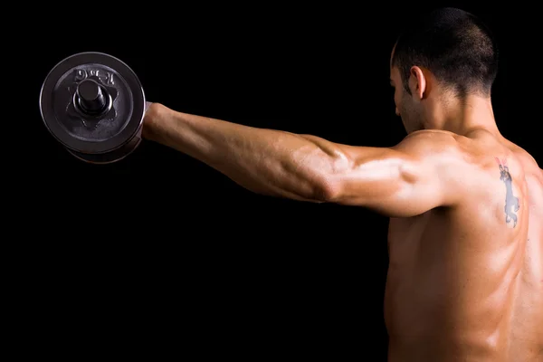 Visão traseira de um jovem fisiculturista do sexo masculino fazendo exercícios de peso pesado Fotografia De Stock