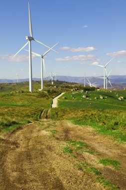 White wind turbines in the top of the mountain clipart