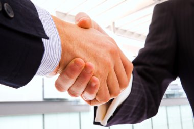 Closeup of business shaking hands over a deal clipart