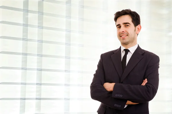 Encerramento de um jovem homem de negócios sorrindo de pé no escritório — Fotografia de Stock