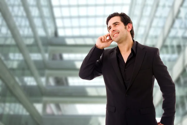 近代的なオフィスでの携帯電話で話すこと幸せな若いビジネスマン — ストック写真