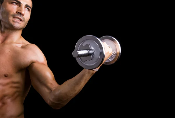 Poderoso homem muscular levantando pesos sobre fundo preto — Fotografia de Stock