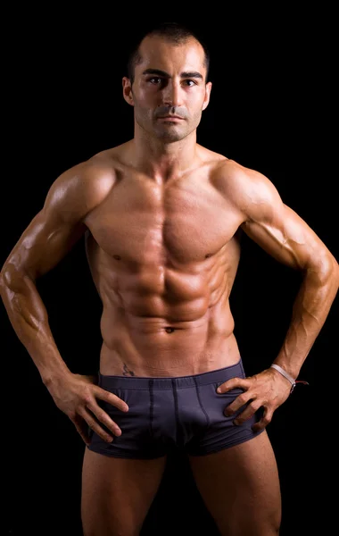 Sexy muscular jovem homem contra preto fundo — Fotografia de Stock