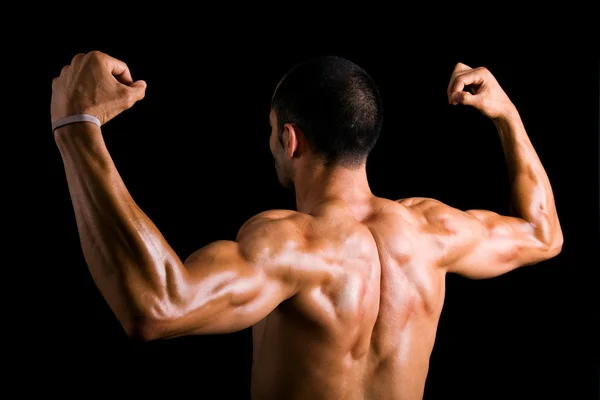 Porträt eines starken Rückens eines jungen, muskulösen Mannes gegen Schwarz — Stockfoto