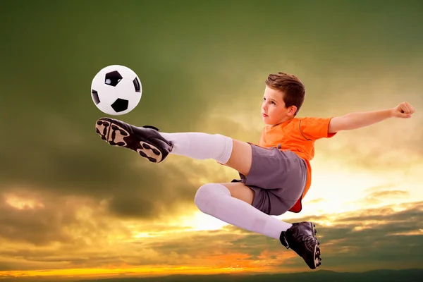 Imagen de un joven futbolista haciendo patada voladora con pelota —  Fotos de Stock